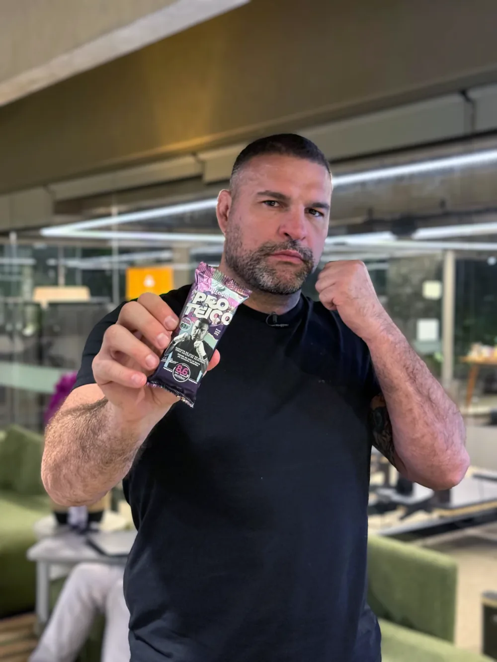 Homem segurando a embalagem do picolé de açaí proteico zero.